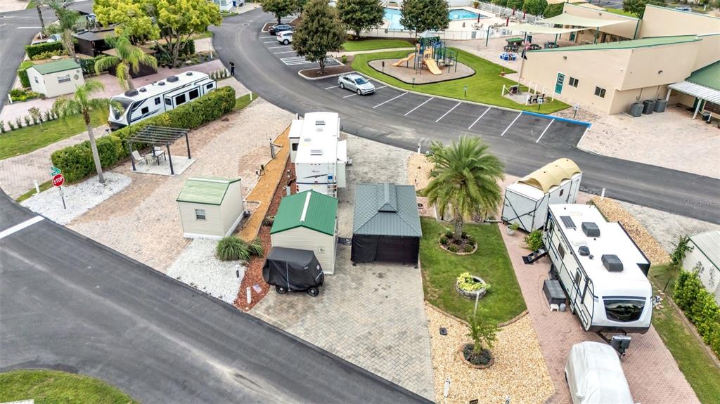 An aerial view shows a paved RV park lot with two trailers, sheds, and landscaping — 16414 BAY STREET, CLERMONT, FL