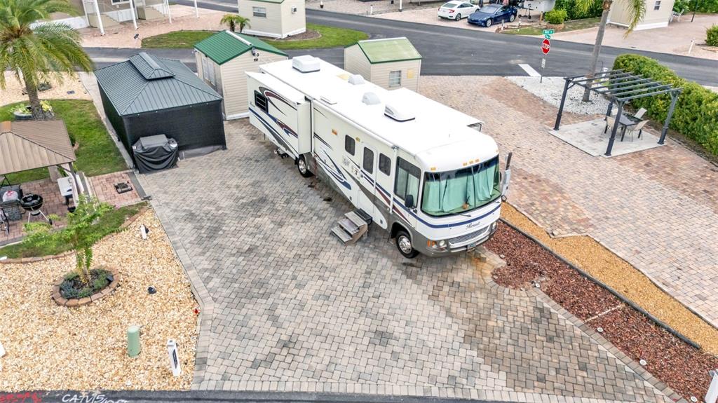 An aerial view shows a motorhome parked on a paved lot with two small sheds — 16414 BAY STREET, CLERMONT, FL