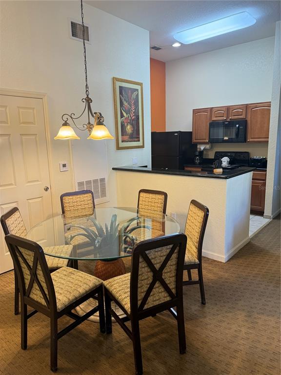 A dining area with a glass table and chairs sits adjacent to an open kitchen — 8100 POINCIANA BOULEVARD UNIT 2601, ORLANDO, FL
