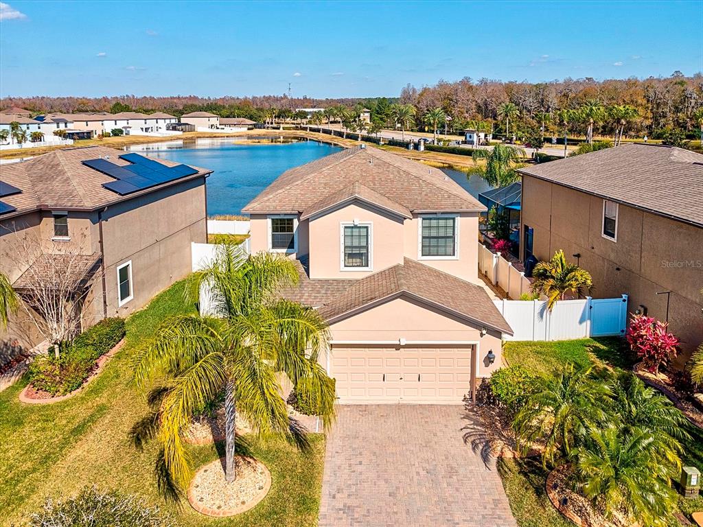 An aerial view of a two-story suburban house with a paved driveway and a lake — 1716 HADDEN HALL PLACE, TRINITY, FL
