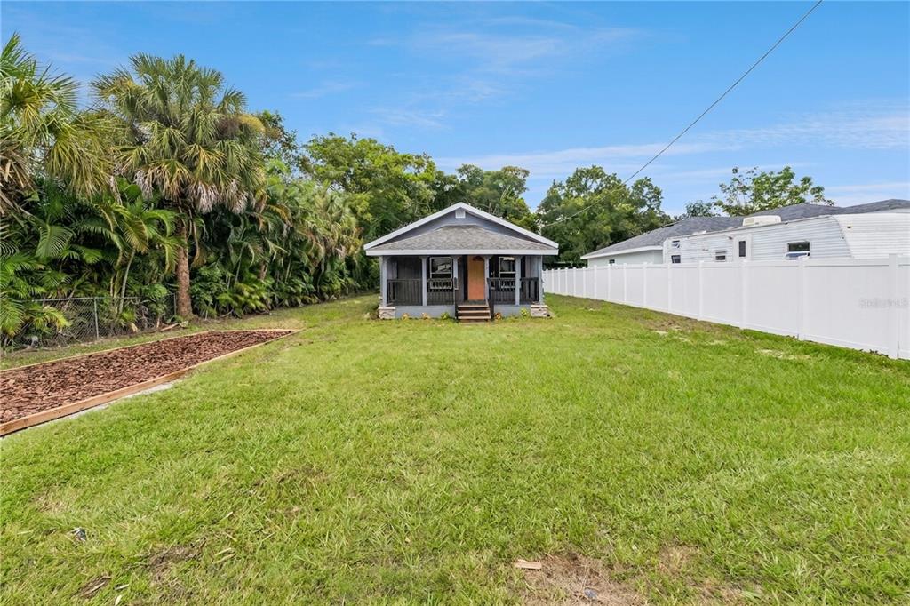 A small, grey, single-story house with a front porch sits in a large, grassy yard — 512 BENNETT STREET, AUBURNDALE, FL