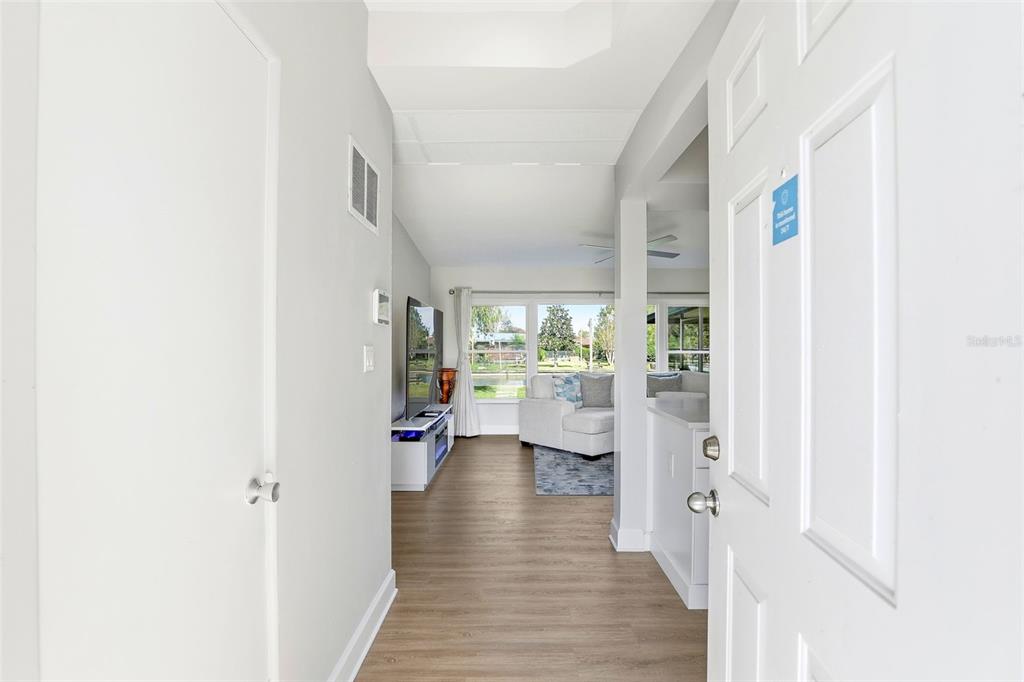 A white front door with house numbers sits beside a red brick wall and lawn — 2705 GULFSTREAM ROAD, ORLANDO, FL
