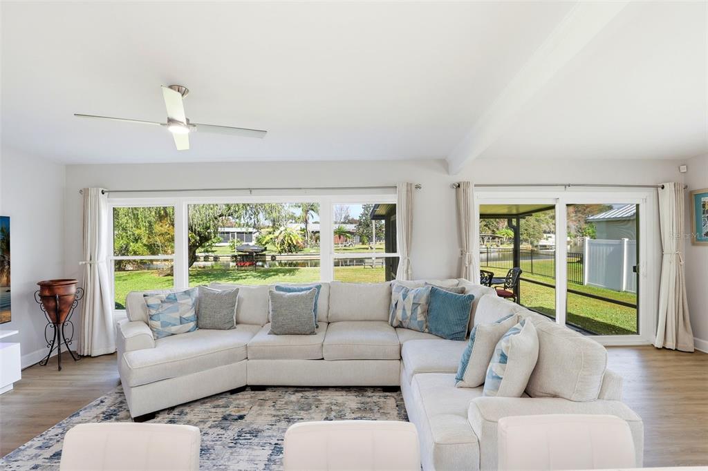 A living room features a large sectional sofa, a patterned area rug, and water views — 2705 GULFSTREAM ROAD, ORLANDO, FL