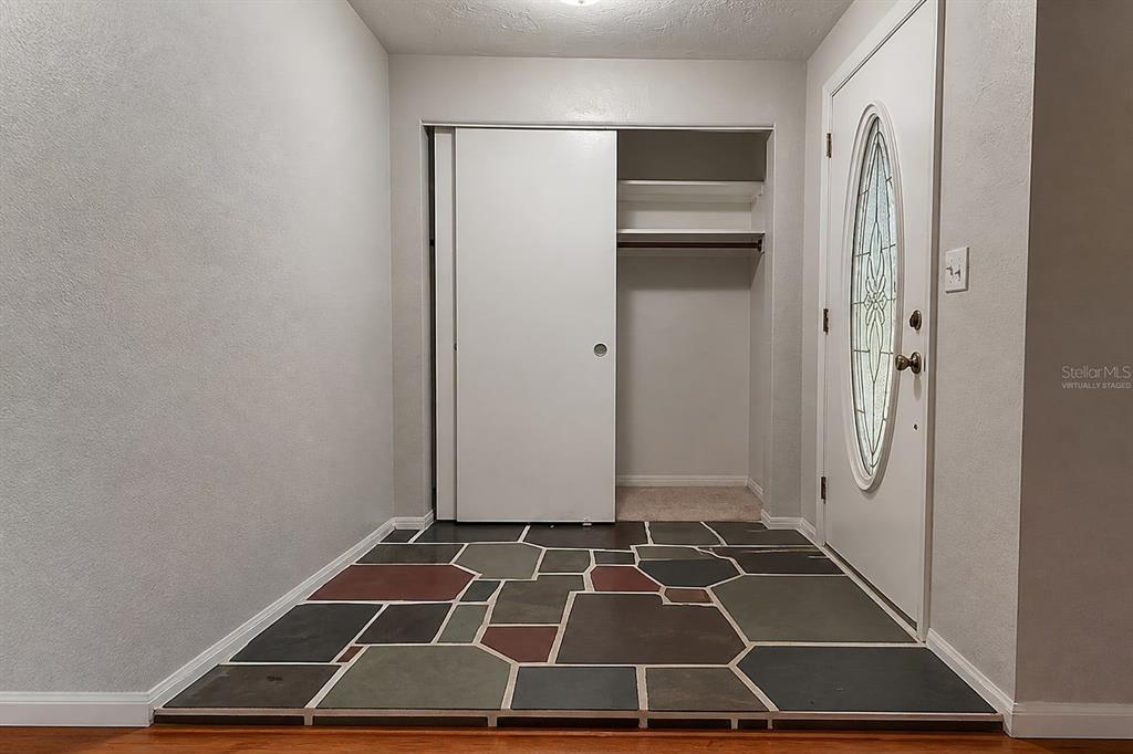 An entryway features a flagstone floor, a sliding-door closet, and a white front door — 13178 88TH AVENUE N, SEMINOLE, FL