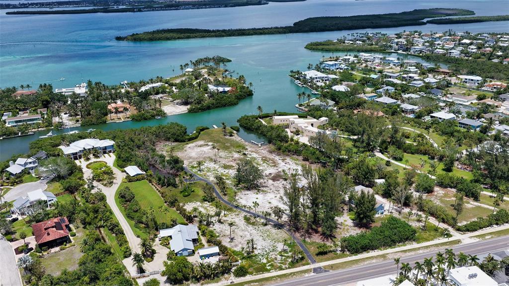 An aerial view shows a coastal property with a large vacant lot and surrounding homes — 6660 & 6664 & 6670 GULF OF MEXICO DRIVE, LONGBOAT KEY, FL