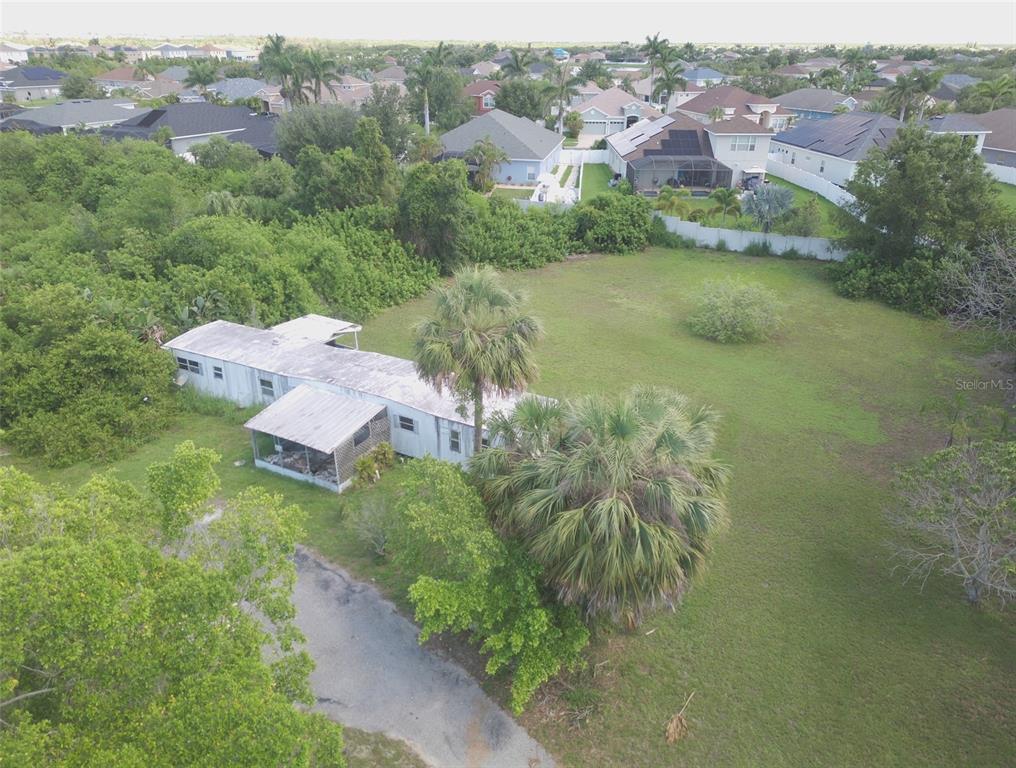 An aerial view shows a single-story house with a metal roof on a large lot — 1603 W SHELL POINT ROAD, RUSKIN, FL