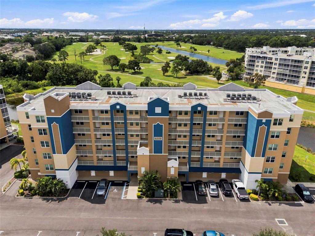 An aerial view of a multi-story apartment building with a parking lot and golf course — 960 STARKEY ROAD UNIT 7205, LARGO, FL