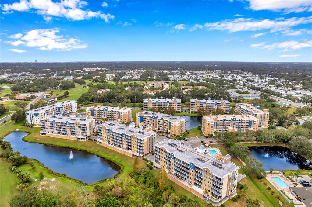 An aerial view shows several multi-story apartment buildings surrounding ponds and swimming pools — 960 STARKEY ROAD UNIT 7205, LARGO, FL