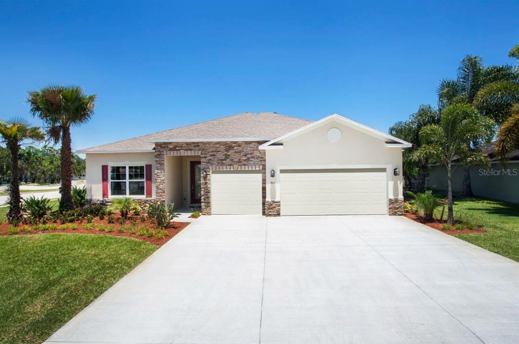 A single-story house with a stone facade, a two-car garage, and palm trees — 1630 NUREMBURG BOULEVARD, PUNTA GORDA, FL
