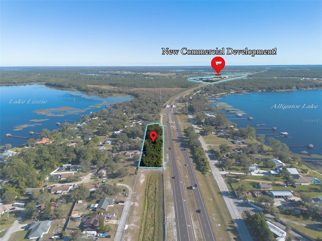An aerial view shows a vacant lot and a commercial development site between two lakes — E IRLO BRONSON MEMORIAL HIGHWAY UNIT 0270, ST CLOUD, FL