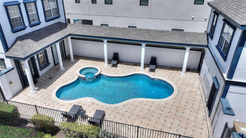 An aerial view shows a courtyard with a swimming pool, spa, and covered patio area — 1524 EUSTON DR, KISSIMMEE, FL