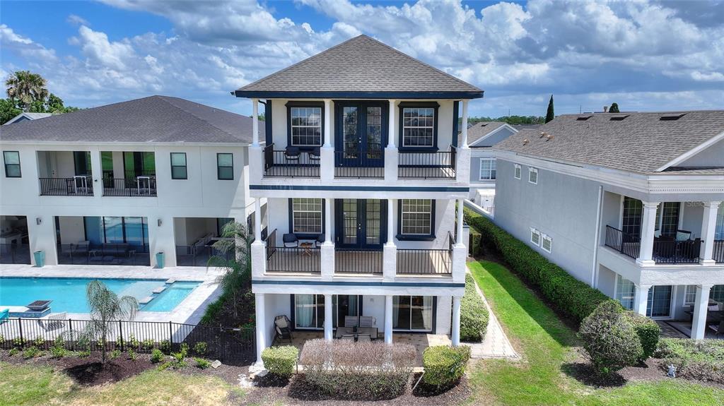 A three-story house with stacked balconies and a pool in the backyard — 1524 EUSTON DR, KISSIMMEE, FL
