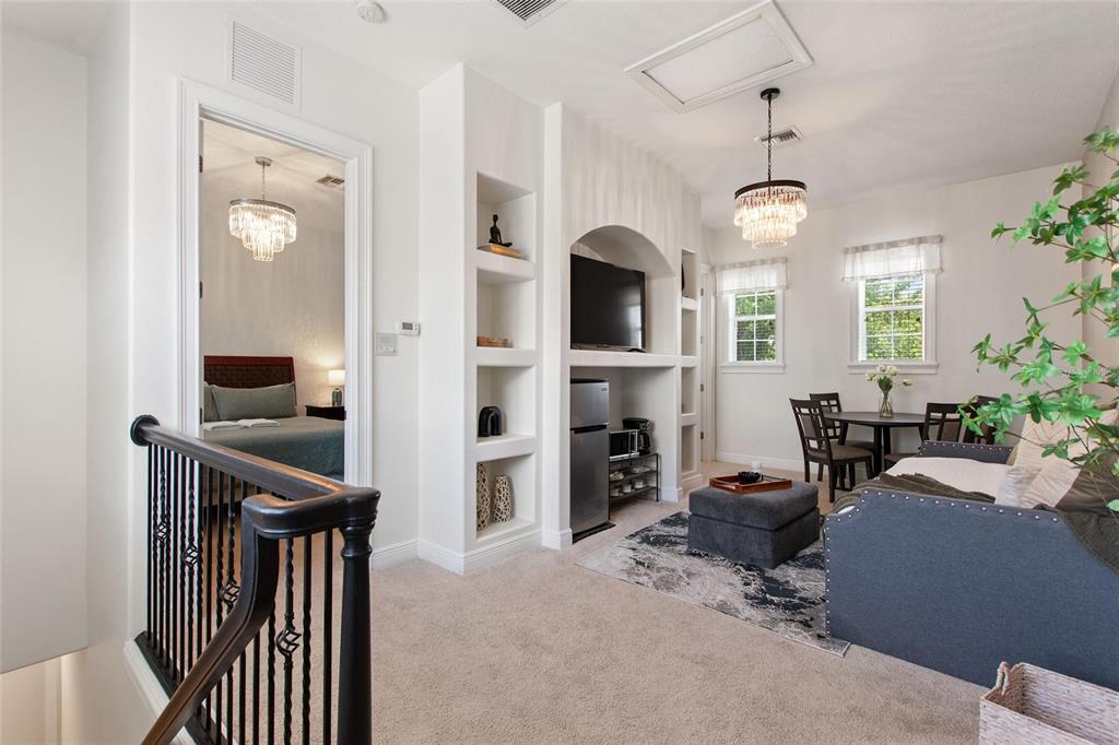 A carpeted loft area features a built-in media center, a small dining set, and a chandelier — 1524 EUSTON DR, KISSIMMEE, FL