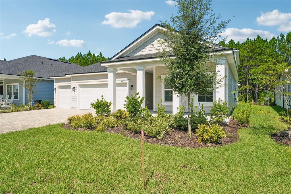 A single-story house with a beige exterior, a two-car garage, and a front porch — 272 SILVER LILY WAY, ST AUGUSTINE, FL