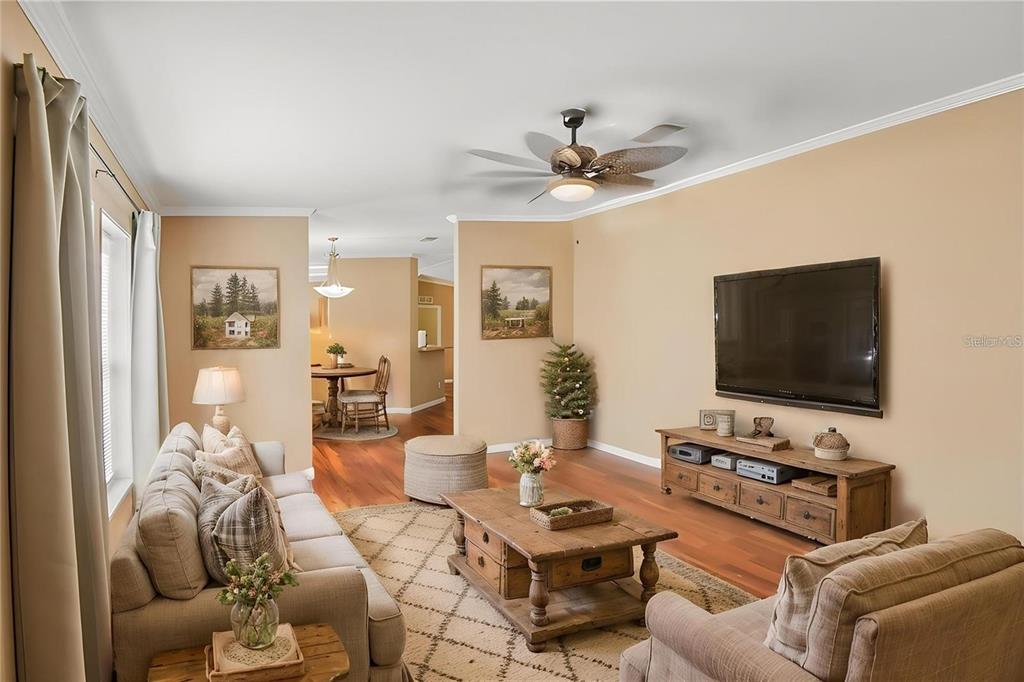 A living room features a beige sofa, wooden coffee table, television, and hardwood flooring — 6221 EMERSON ROAD, BROOKSVILLE, FL