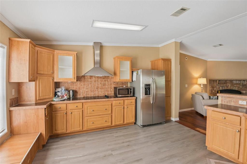 A kitchen features light wood cabinets, stainless steel appliances, and a tile backsplash — 6221 EMERSON ROAD, BROOKSVILLE, FL