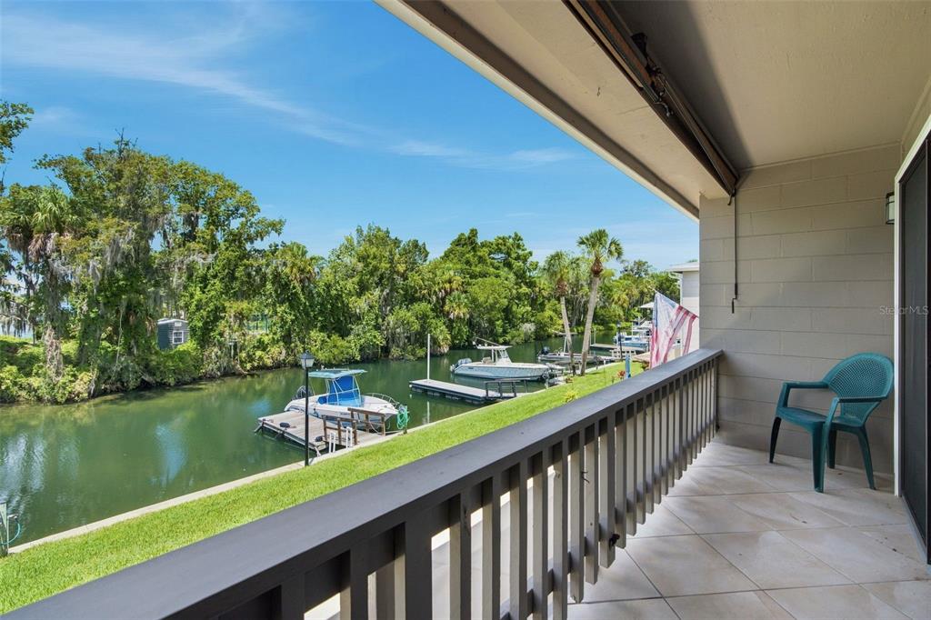 A balcony with a tiled floor and railing overlooks a canal with docked boats — 65 BEACH LANE UNIT N, CRYSTAL RIVER, FL