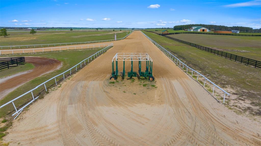 An aerial view shows a horse starting gate positioned on a dirt training track — 12451 NE 20TH STREET, WILLISTON, FL