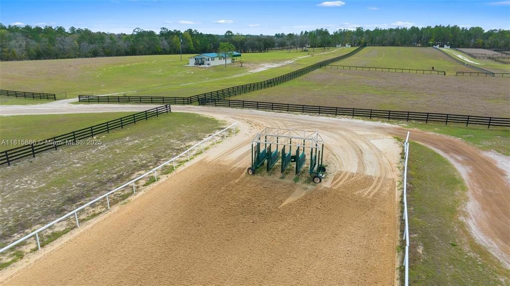 An aerial view shows a horse starting gate in a sandy training ring with fencing — 12451 NE 20TH STREET, WILLISTON, FL