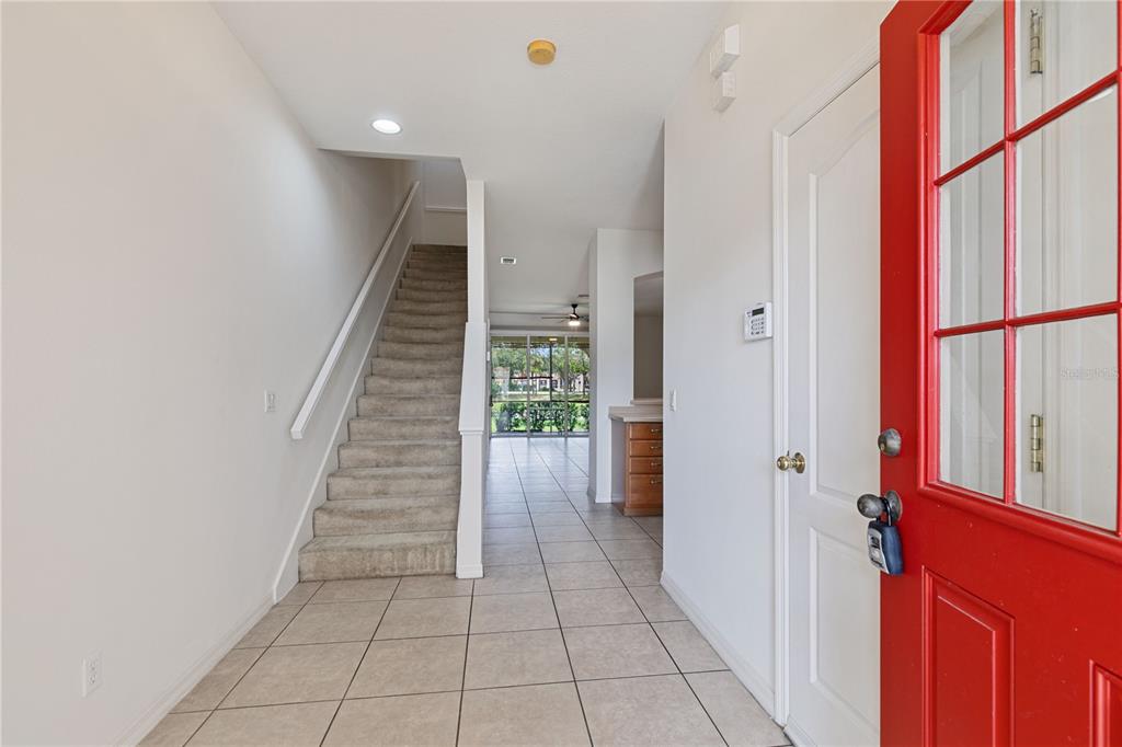 An entryway features a red front door, tiled floors, and a carpeted staircase leading upstairs — 1073 JONAH DRIVE, NORTH PORT, FL