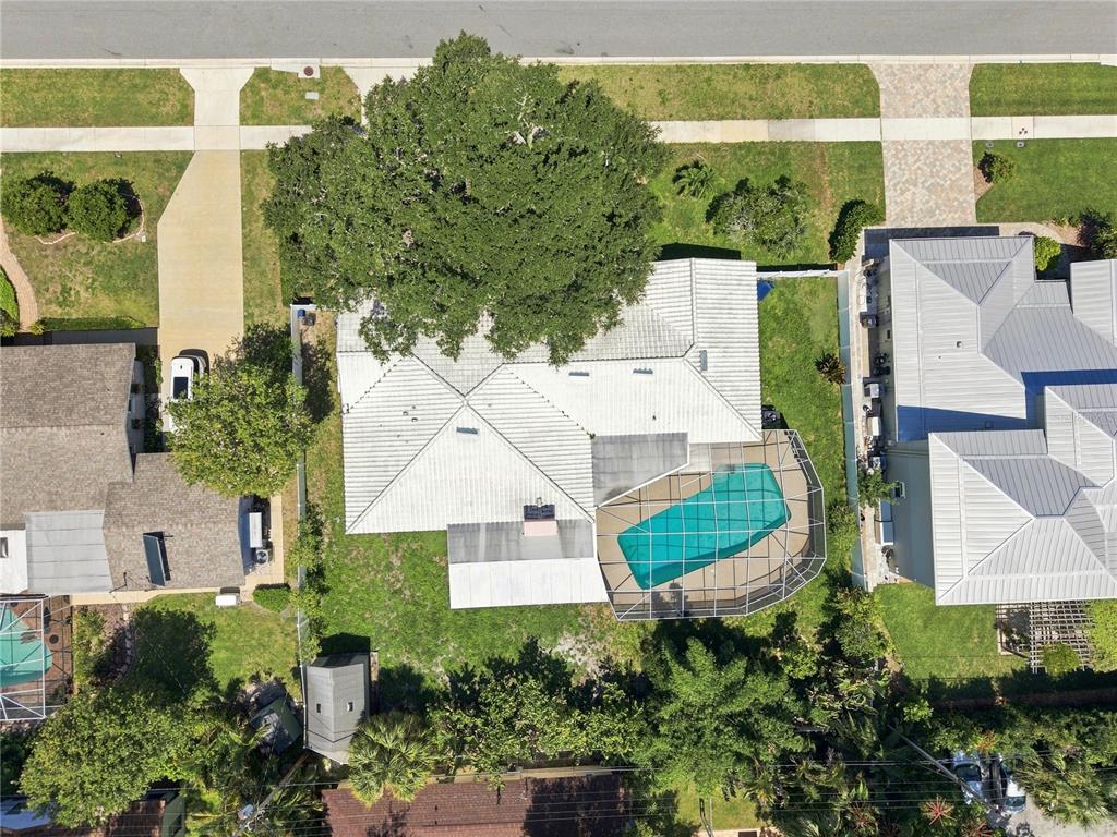 An aerial view shows a house with a white roof, a pool cage, and landscaping — 1361 PINELLAS ROAD, CLEARWATER, FL