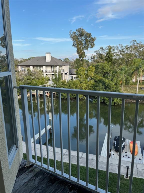 A balcony view overlooking a canal with a boat dock, a jet ski, and houses — 116 BRENT CIRCLE, OLDSMAR, FL