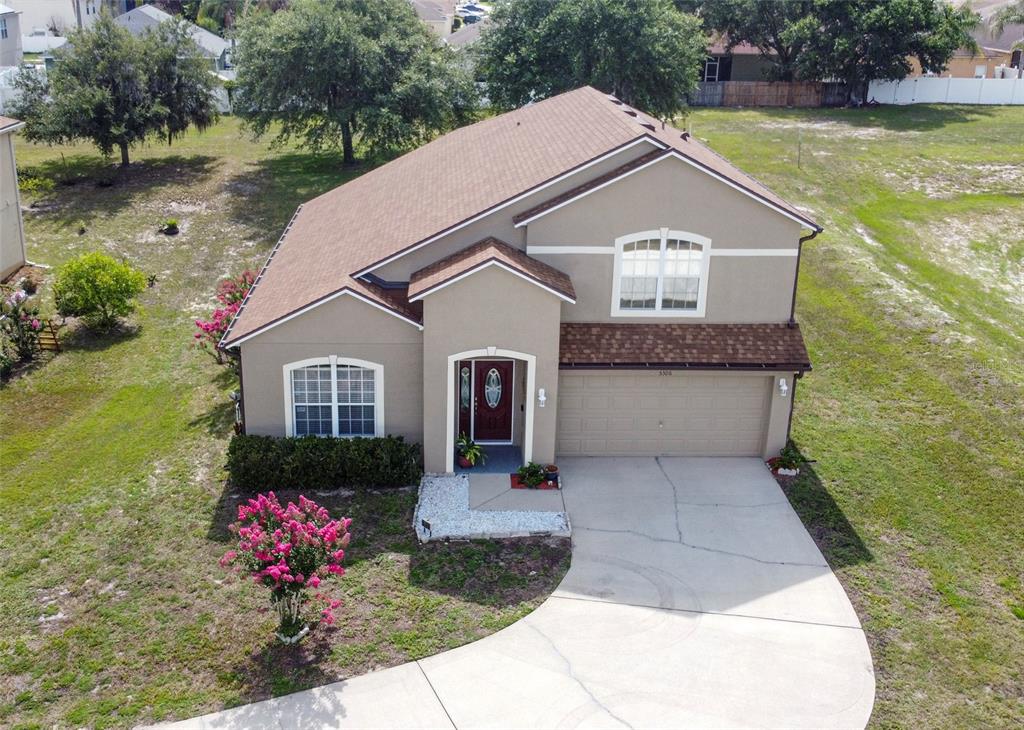 An aerial view of a two-story suburban house with a brown roof and beige siding — 5306 RABBIT RIDGE TRAIL, ORLANDO, FL