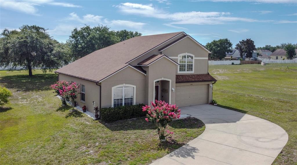 An aerial view shows a two-story tan house with a garage and a curved driveway — 5306 RABBIT RIDGE TRAIL, ORLANDO, FL