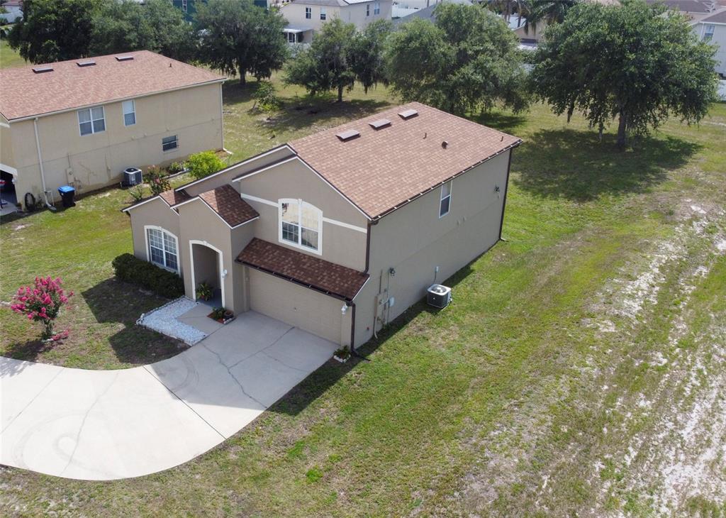 An aerial view shows a two-story suburban house with a tan exterior and brown roof — 5306 RABBIT RIDGE TRAIL, ORLANDO, FL