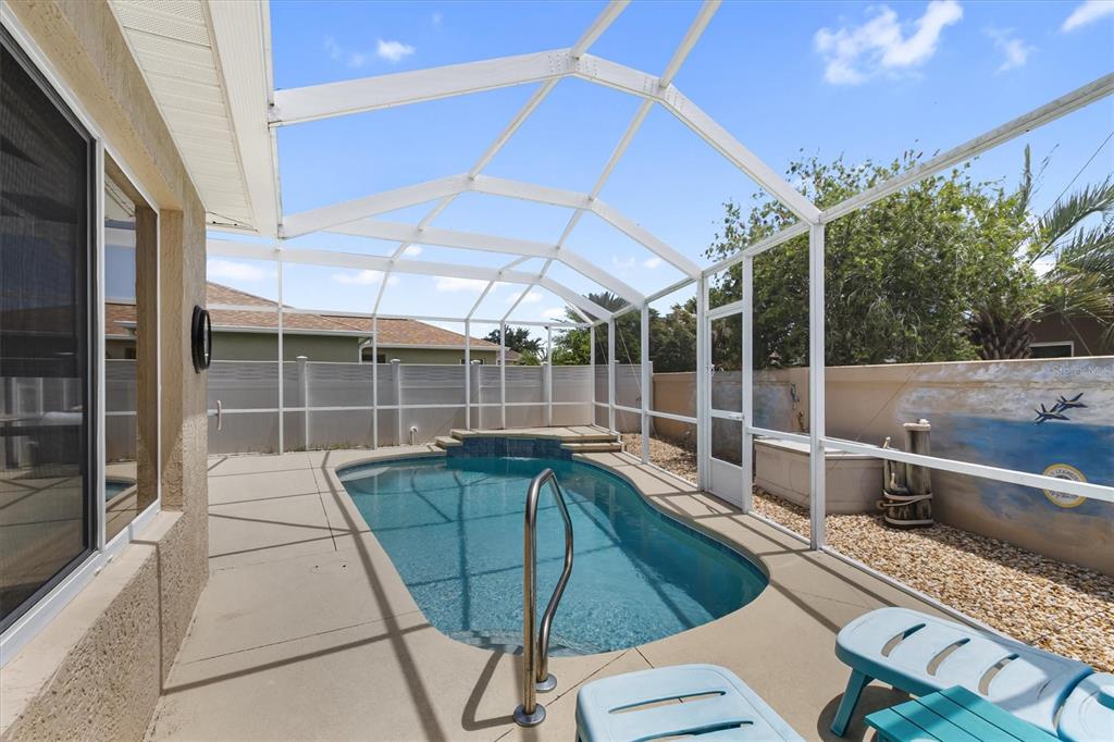 A screened-in swimming pool with a concrete deck and a mural on the back wall — 1068 BURNETTOWN PLACE, THE VILLAGES, FL
