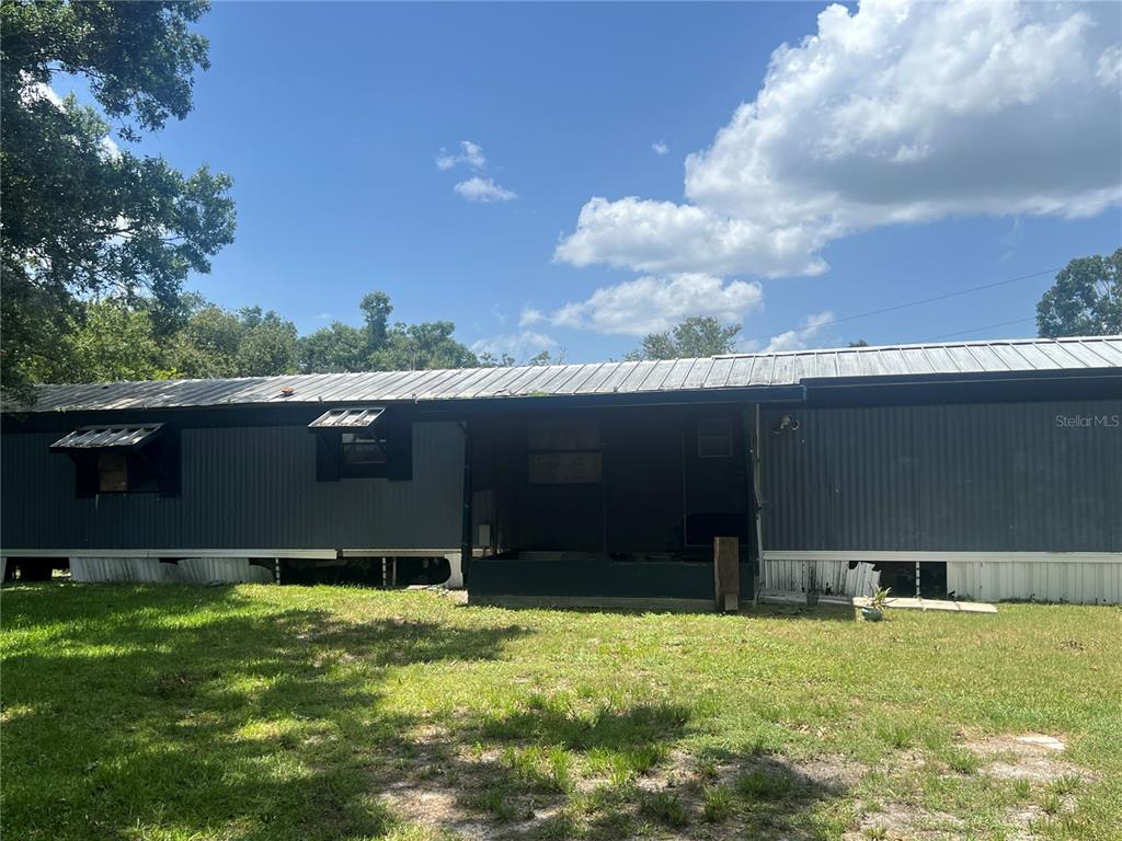 A single-story manufactured home with gray siding and a metal roof sits on a lawn — 2536 CANNON STREET, LAKELAND, FL