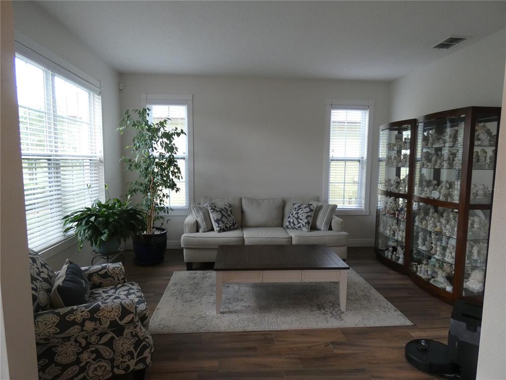 A two-story suburban house with a gray stucco exterior, a three-car garage, and a paved driveway — 14632 BRADDOCK OAK DRIVE, ORLANDO, FL