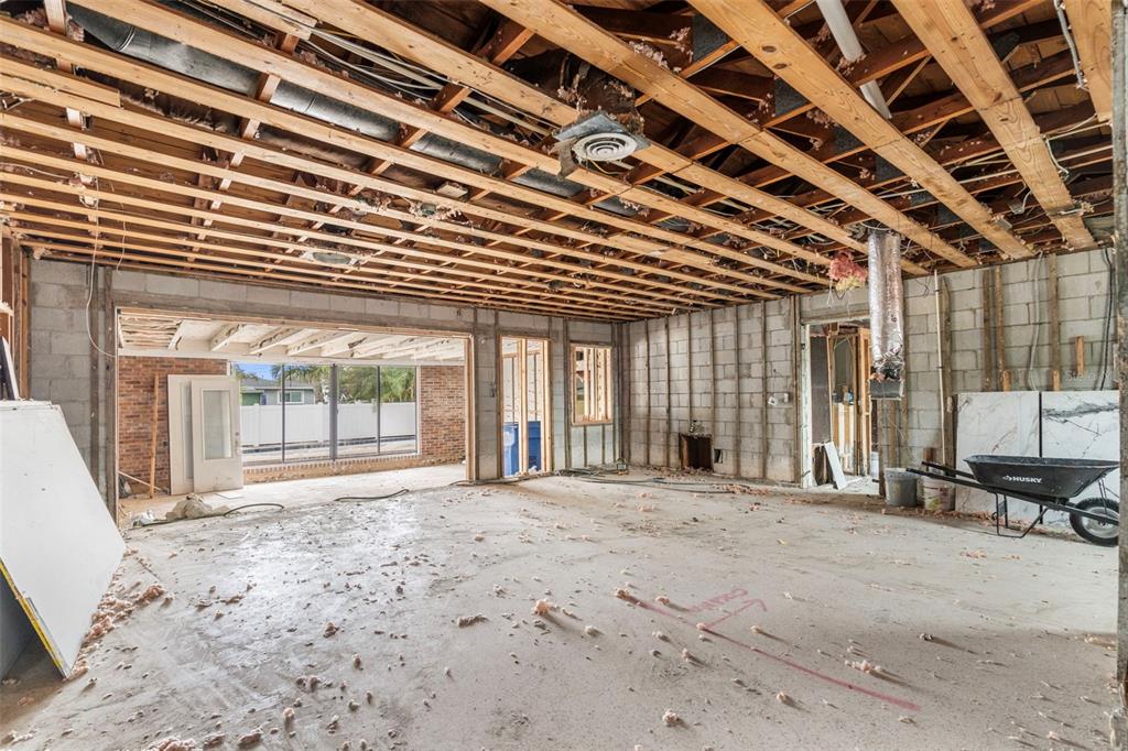 An interior view of a room under construction with exposed ceiling joists and concrete block walls — 9570 SUN ISLE DRIVE NE, ST PETERSBURG, FL