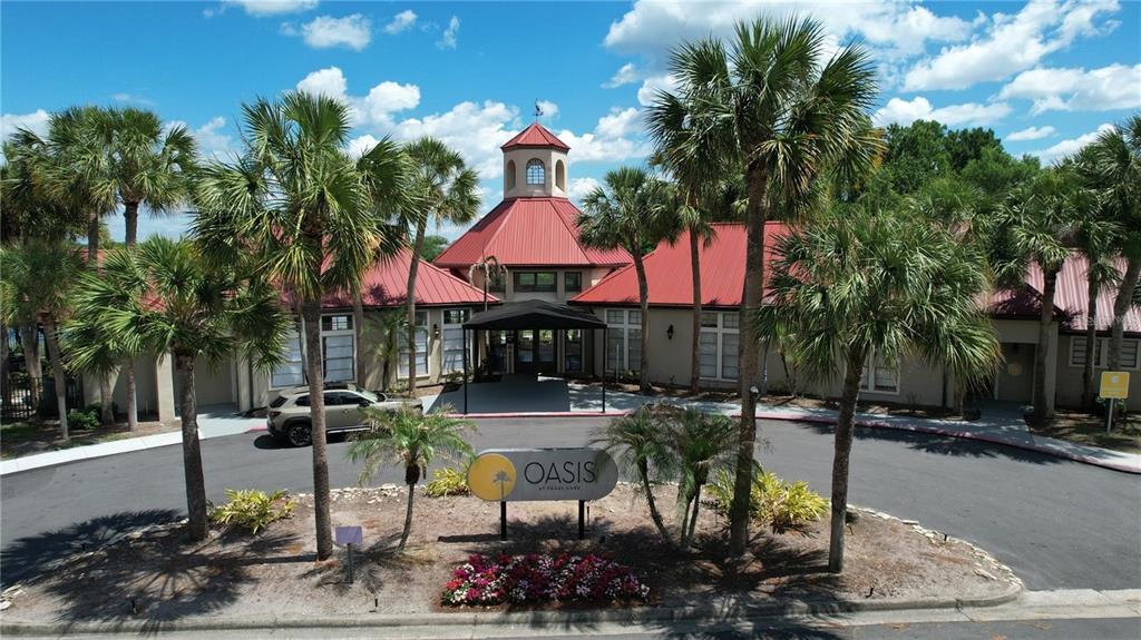 An aerial view shows the exterior of a community clubhouse with a red metal roof — 232 AFTON SQUARE UNIT 207, ALTAMONTE SPRINGS, FL