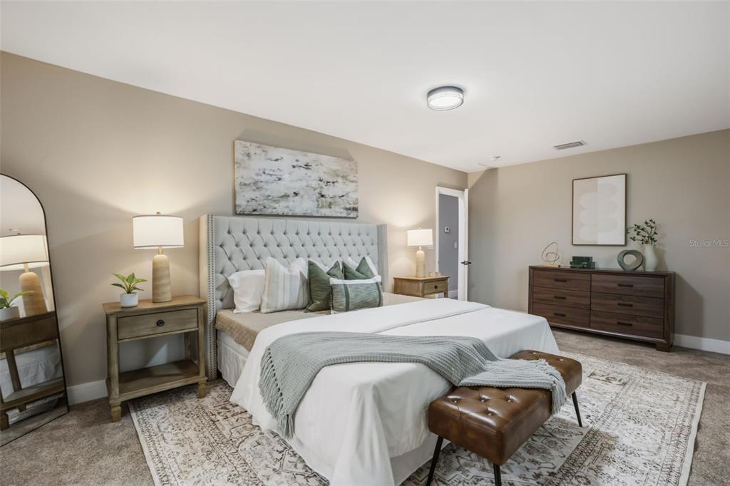 A bedroom features a tufted headboard, a wooden dresser, a leather bench, and a rug — 15 E LAUREL STREET, APOPKA, FL