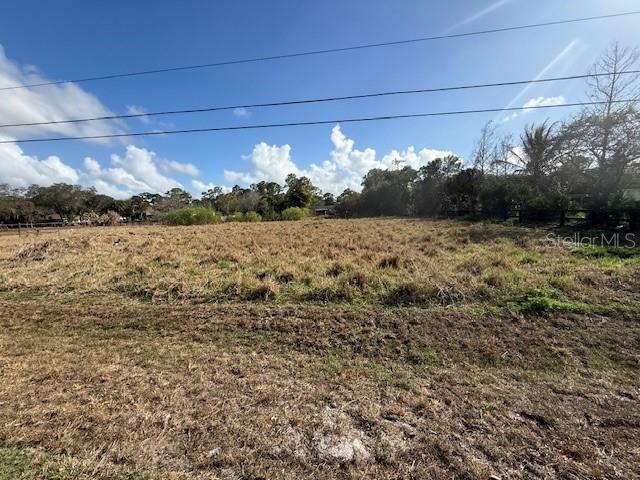 A large, flat, grassy vacant lot under a blue sky with scattered clouds — 17892 75TH PLACE N, LOXAHATCHEE, FL