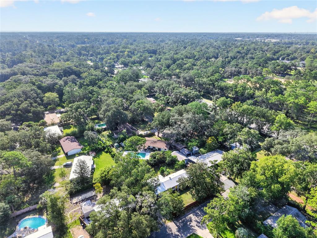 An aerial view shows a house with a metal roof, a gazebo, and surrounding trees — 3929 NW 20TH TERRACE, GAINESVILLE, FL