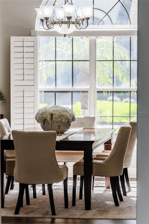 A dining room features a dark wood table, upholstered chairs, and a large arched window — 1221 VISTA HILLS DRIVE, LAKELAND, FL