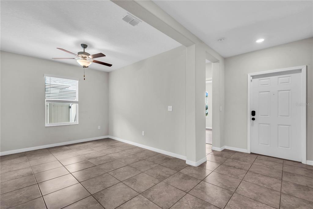 An entryway leads into a tiled room featuring a ceiling fan and a window — 1739 BROAD WINGED HAWK DRIVE, RUSKIN, FL