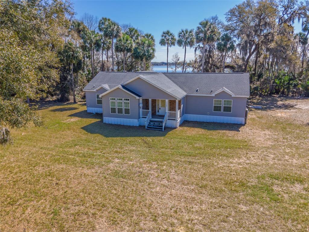 An aerial view of a single-story house with gray siding and a front porch — 17482 SE 34TH LANE, OCKLAWAHA, FL
