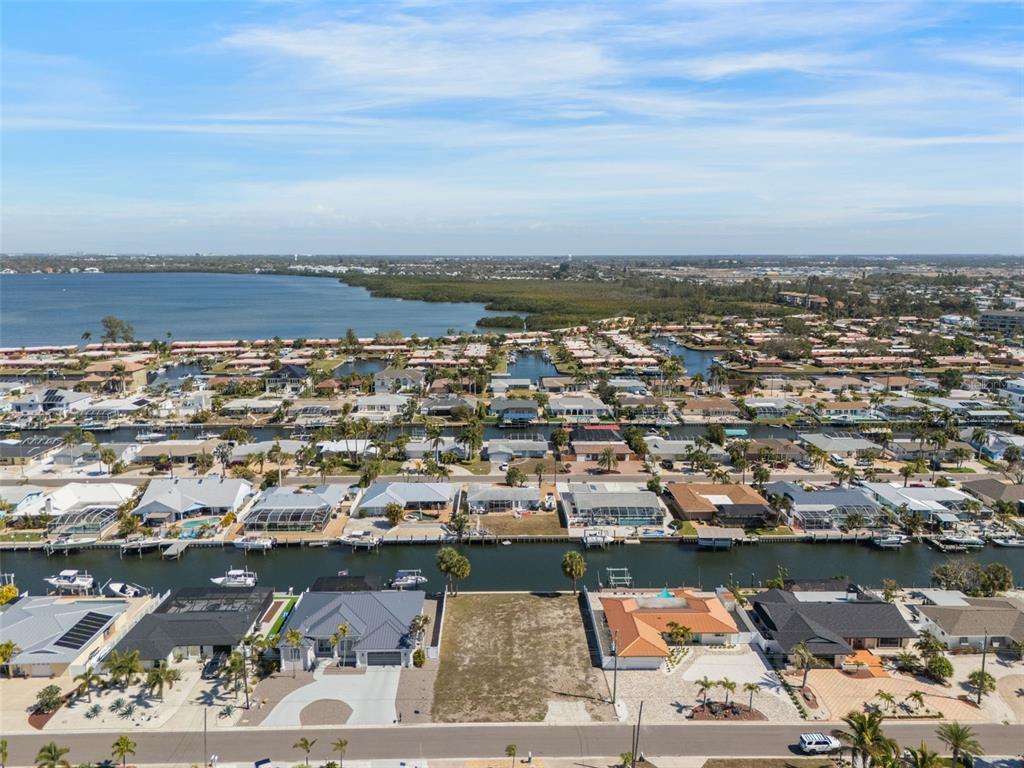An aerial view shows a vacant waterfront lot situated between two houses along a canal — 4007 COCONUT TERRACE, BRADENTON, FL