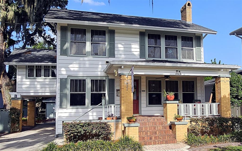 A white house with green shutters features a brick porch and steps leading to a door — 821 N EOLA DRIVE, ORLANDO, FL