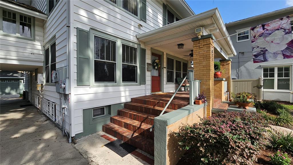 A two-story white house with green shutters features a front porch and a side driveway — 821 N EOLA DRIVE, ORLANDO, FL