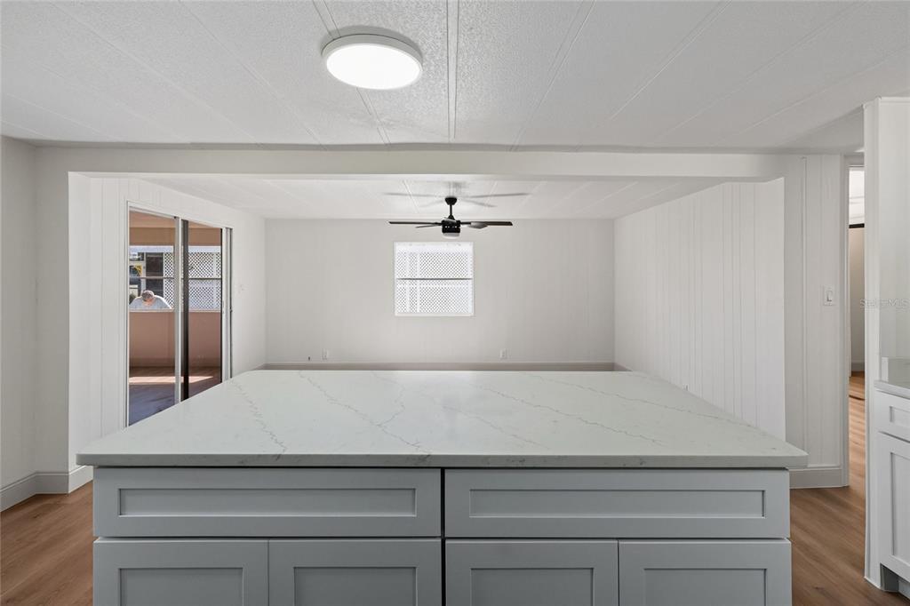 A large kitchen island with a white quartz countertop sits in a bright, open room — 2055 S FLORAL AVENUE UNIT 55, BARTOW, FL
