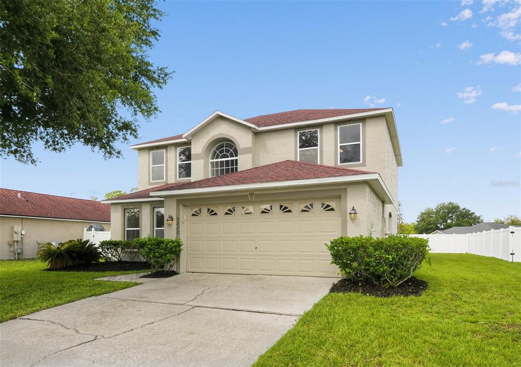 A two-story house with a beige stucco exterior, a two-car garage, and a shingled roof — 3222 RESERVE COURT, ORLANDO, FL