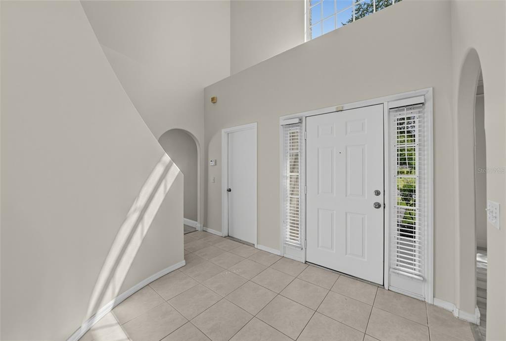 An entryway with tile flooring, a white front door, and a high ceiling — 3222 RESERVE COURT, ORLANDO, FL