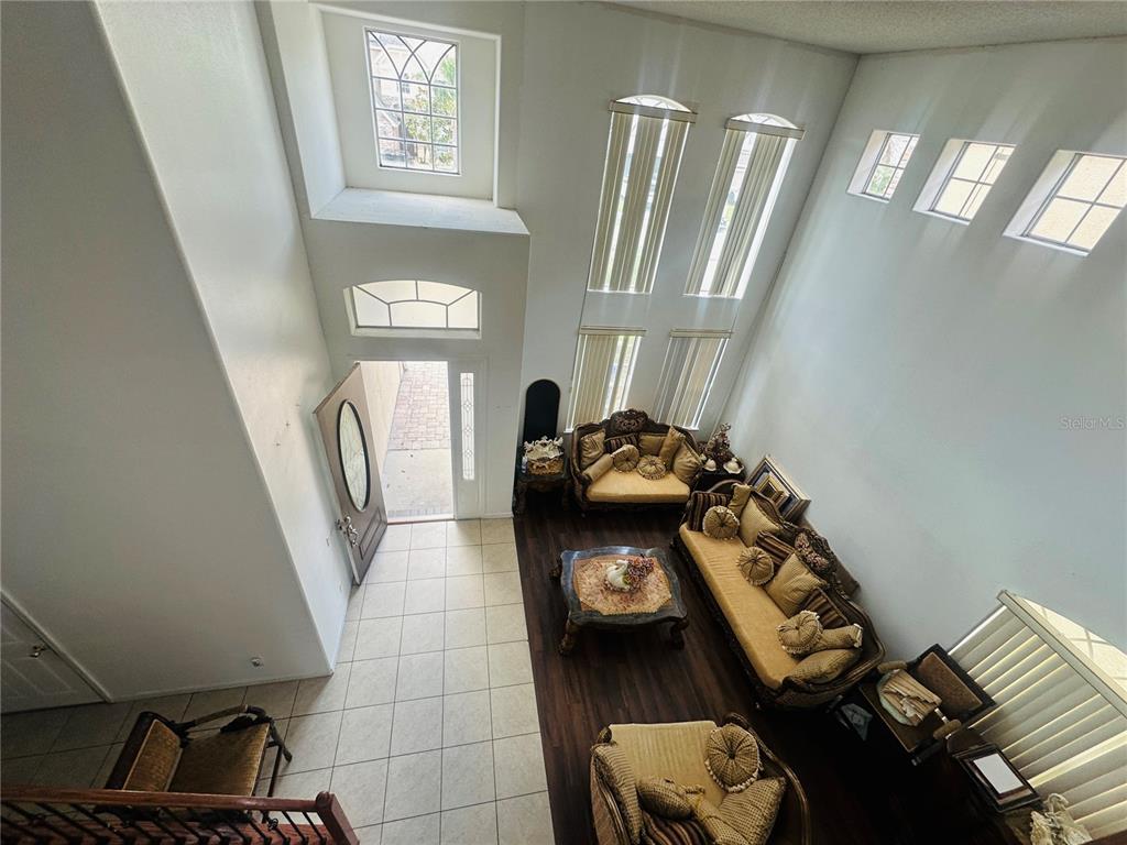 A high-angle view of a living room with vaulted ceilings, tile flooring, and wood floors — 2530 SAND ARBOR CIRCLE, ORLANDO, FL