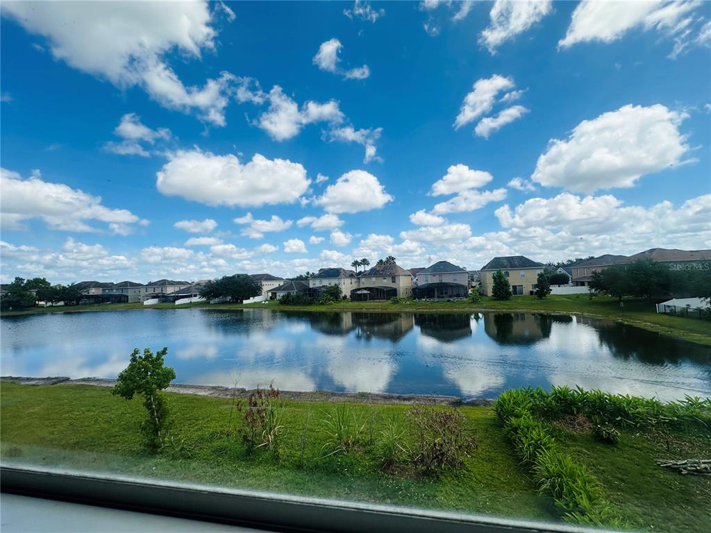 A view of a lake and residential houses under a blue sky with clouds — 2530 SAND ARBOR CIRCLE, ORLANDO, FL