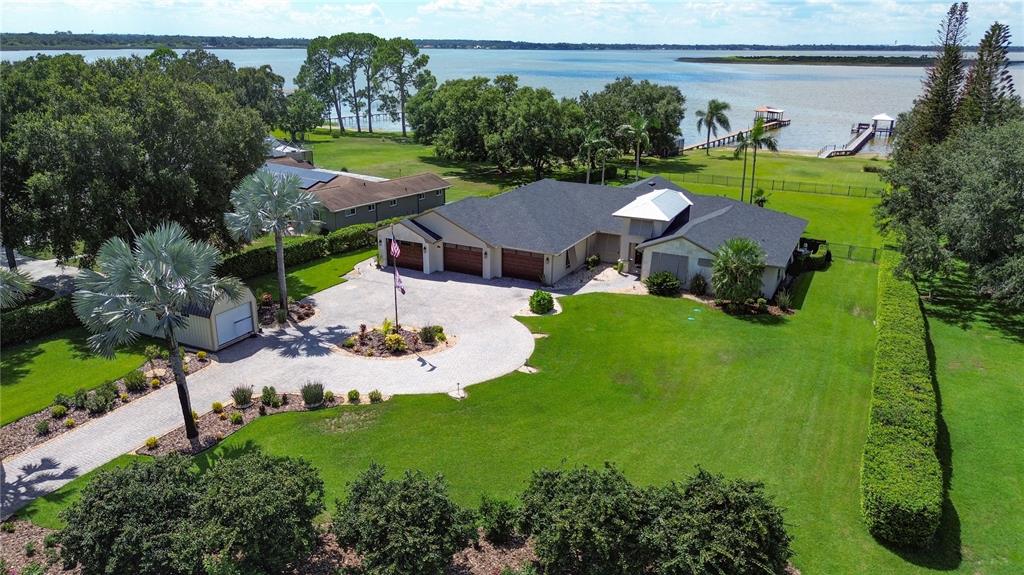 An aerial view of a single-story house with a circular driveway and waterfront access — 3640 CRUMP ROAD, WINTER HAVEN, FL