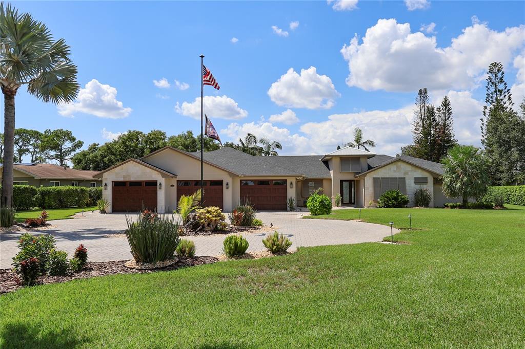 A single-story house with a three-car garage, a paved driveway, and a flag pole — 3640 CRUMP ROAD, WINTER HAVEN, FL